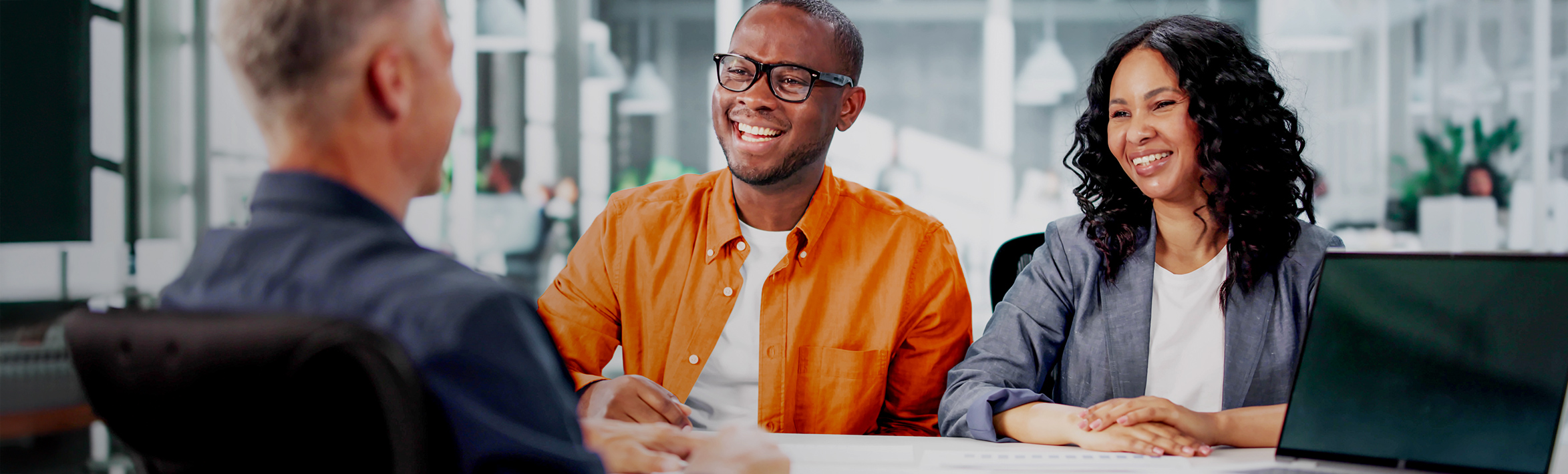 An adult smiling and looking away from the camera.